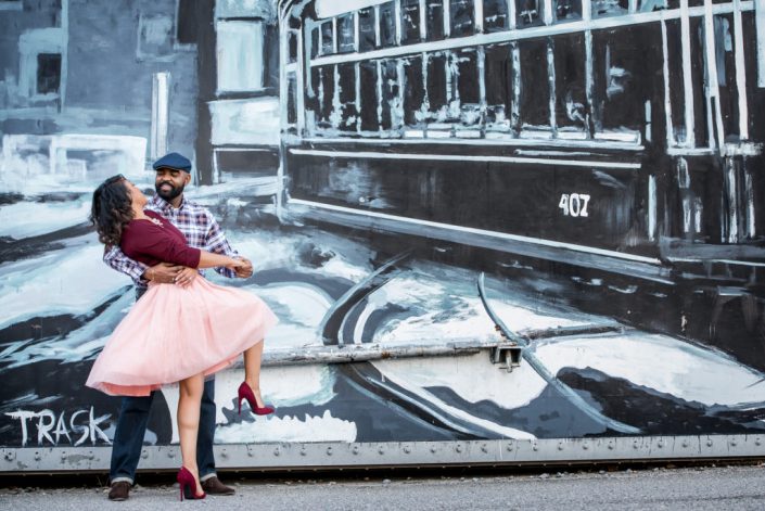 Dressy couple dance in front of wall mural at the Flood Wall in Richmond, VA