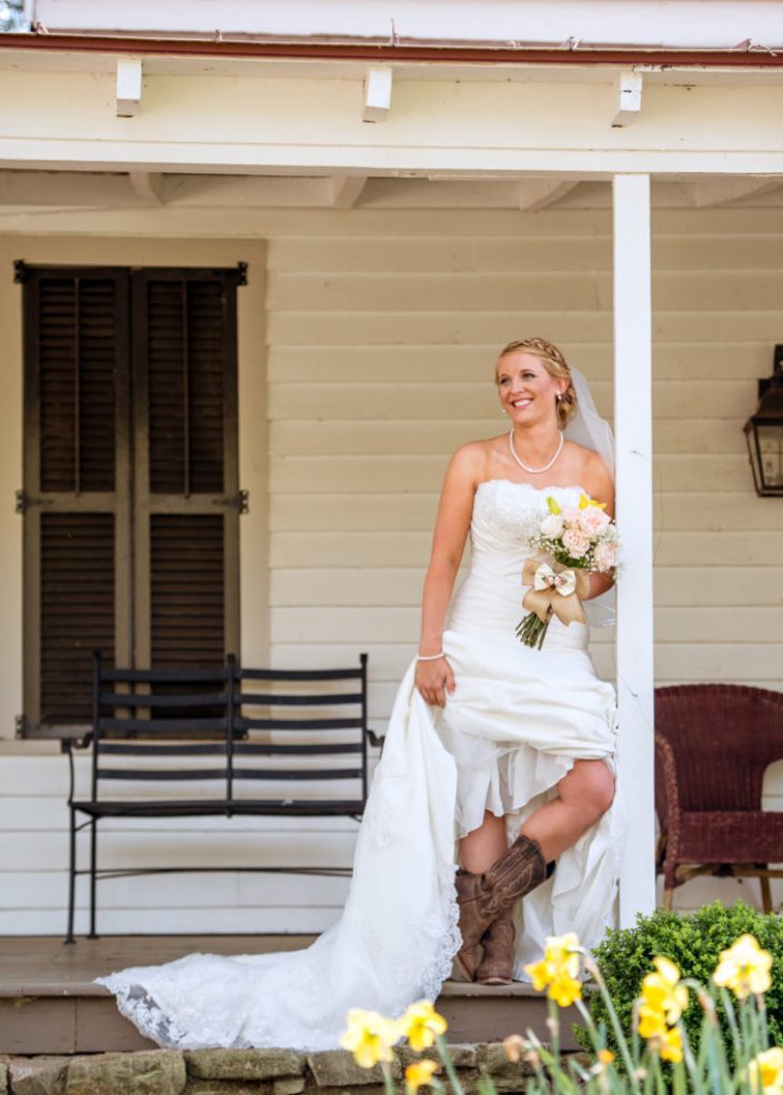 County bride poses in cowboy boots for portait at Mill at Fine Creek, VA