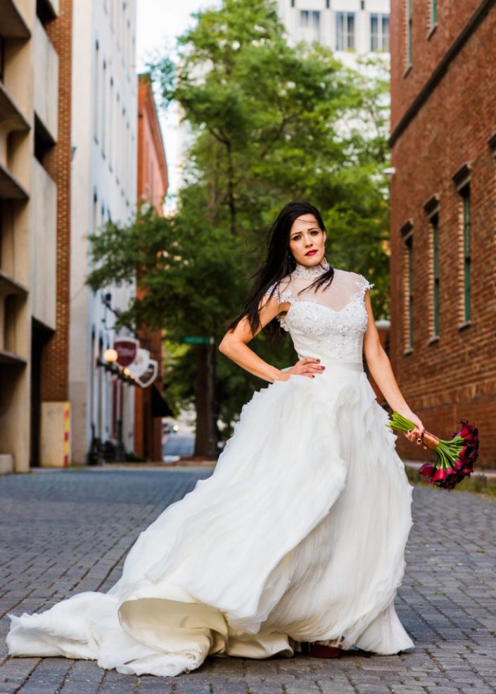 Gorgous bride with flowy gown in the wind poses for bridal portrait in downtown RVA