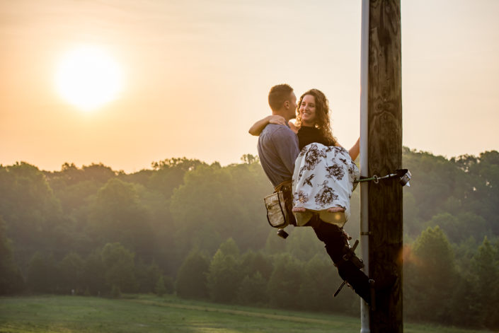 Lineman engagement photo carries his bride to be up a pole Louisa, VA