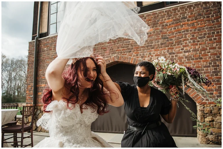 Melissa Vine with the Hive Collective helps a bride during a gust of wind with her veil