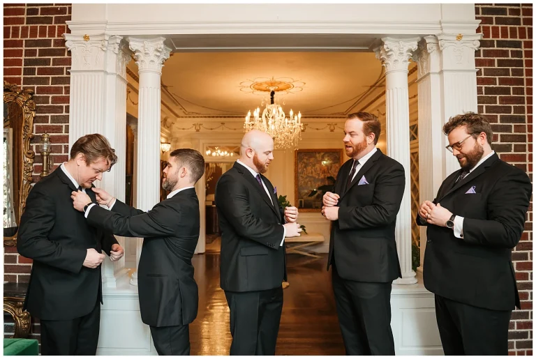 Groomsmen get dressed in the Rockerfeller room at Mankin Mansion