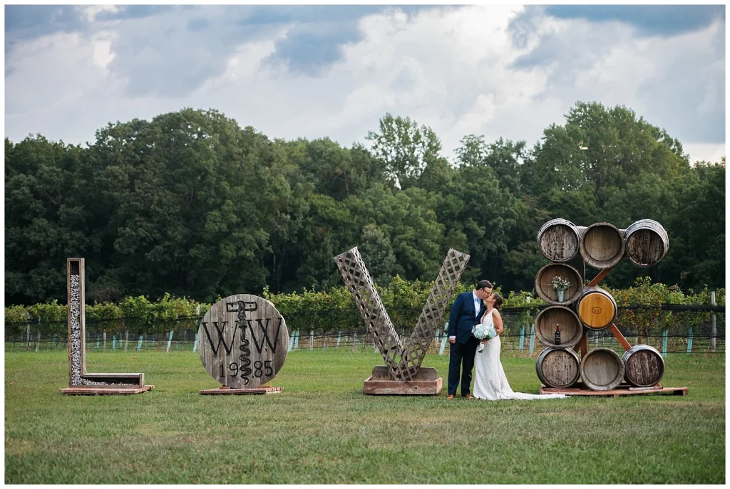 Bride and Groom take a portrait by the Williamsburg Winery Love sign