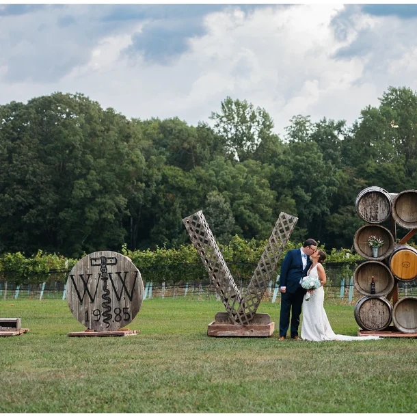 Bride and Groom take a portrait by the Williamsburg Winery Love sign