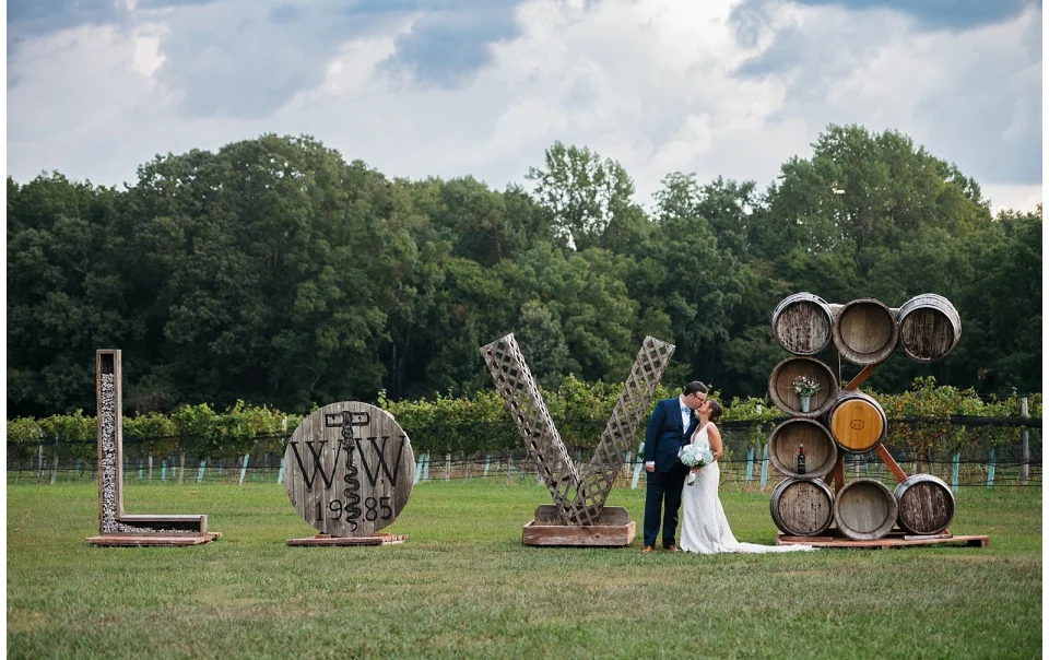 Bride and Groom take a portrait by the Williamsburg Winery Love sign